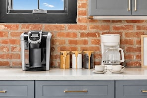 A kitchen with a coffee maker, a glass carafe, and a coffee pot on the counter. - Private Rooftop Skyline Views - Weho - Sleeps 10 (Nashville)