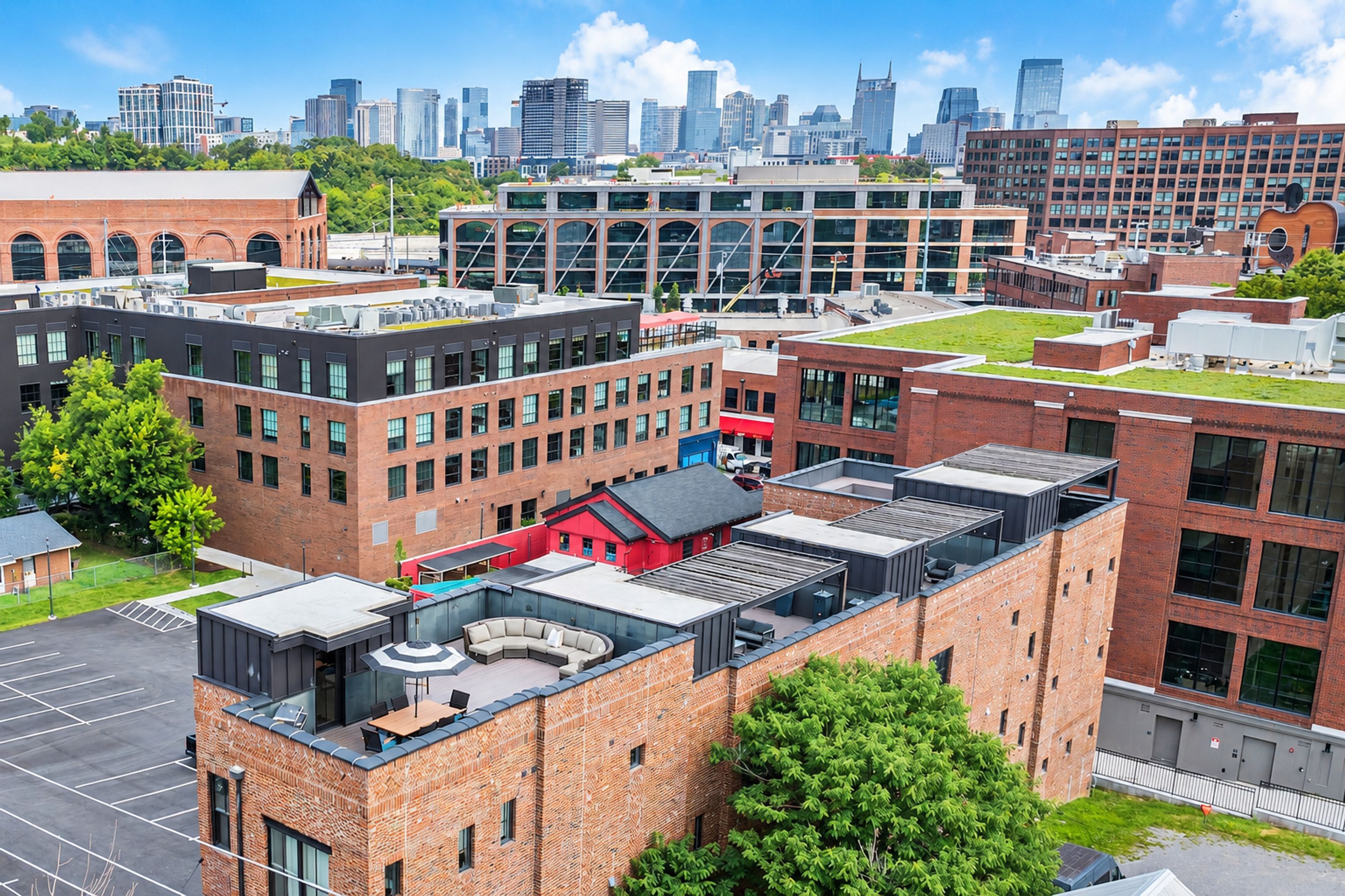 A multi-story building with a rooftop terrace, surrounded by other buildings and a city skyline in the background.