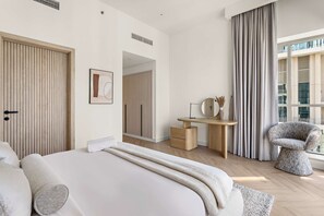 A modern bedroom with a large bed, a desk, a chair, and a view of the outside. - Silkhaus Burj Khalifa View Renovated 2bdr (Dubai)