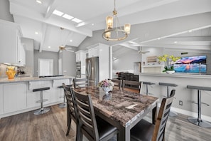 A modern kitchen with white cabinetry, a granite countertop, and stainless steel appliances. - Lagoonfront 3BR Pickleball Kayaks Basketball (Carlsbad)