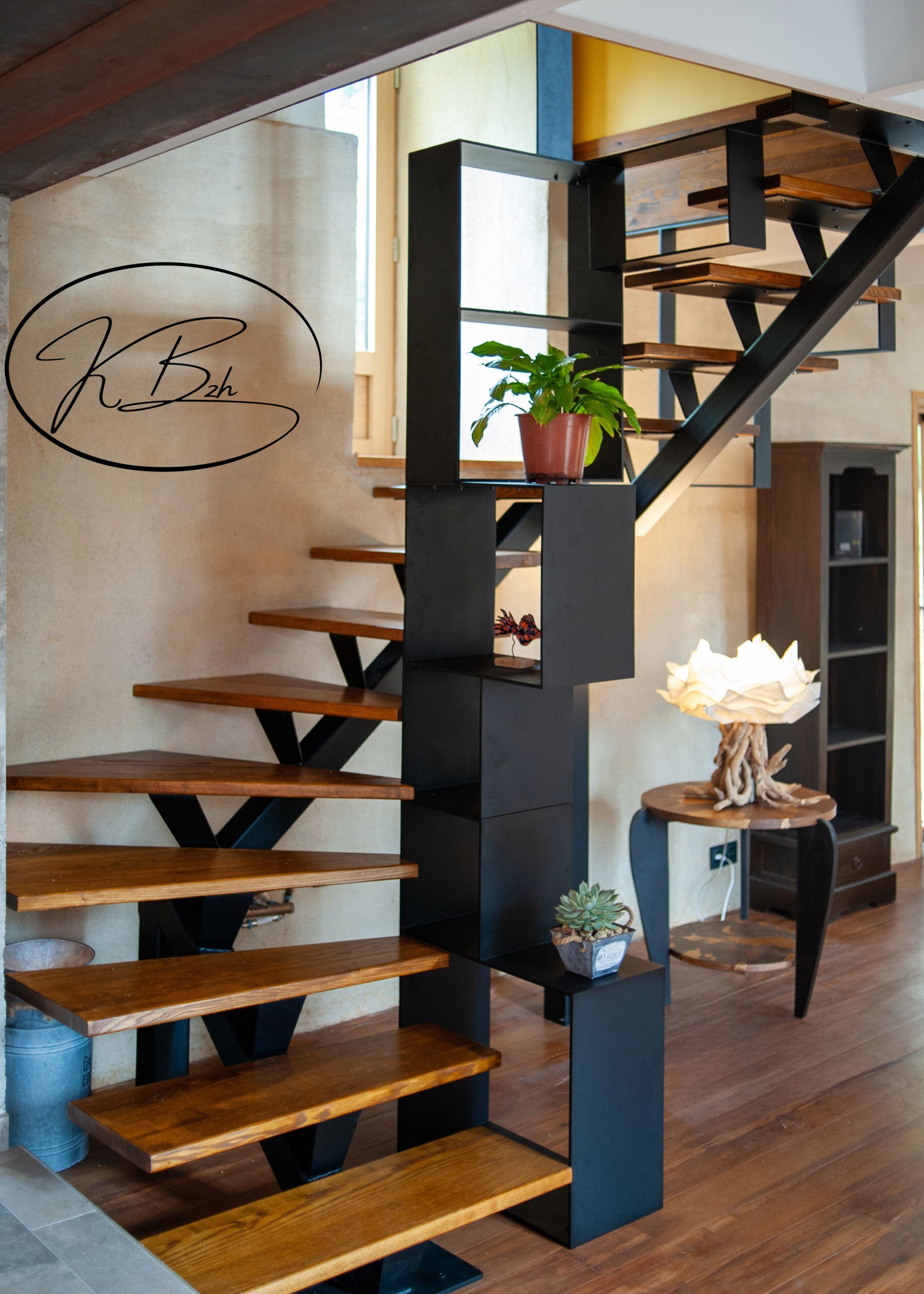 A staircase with wooden steps and black metal supports, a potted plant on the landing, and a small table with a decorative item.