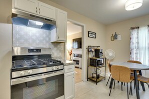 A modern kitchen with a gas stove, oven, and a dining area with a table and chairs. - 5 Mi to Dtwn & Bricktown! Quaint Escape (Oklahoma City)
