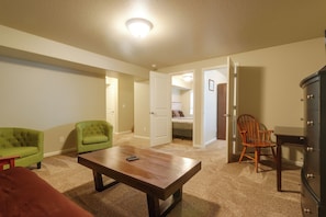 A room with a wooden table, two chairs, a green armchair, a brown ottoman, and a dark-colored dresser. - Family-friendly Home! Walk to Windsor Lake (Windsor)