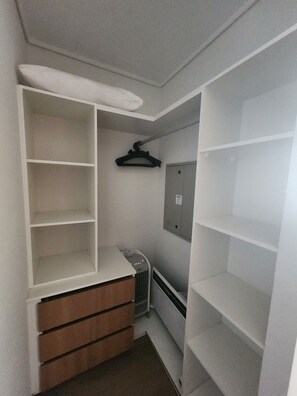 A compact walk-in closet with built-in shelving, a hanging rod, and a radiator. - Marvelous 2-bedroom apartment in peaceful Ñuñoa neighborhood (Ñuñoa)