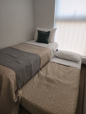 A single bed with a quilted bedspread, a pillow, and a blanket. - Marvelous 2-bedroom apartment in peaceful Ñuñoa neighborhood (Ñuñoa)
