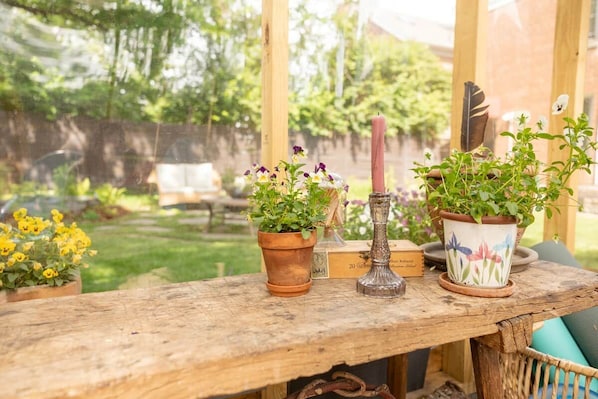 A wooden table with potted plants and a candle.