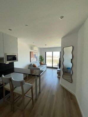 Un interior modern amb cuina, zona de menjador i espai de sala d'estar.