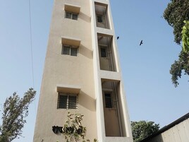 A multi-story building with several windows and a visible balcony.