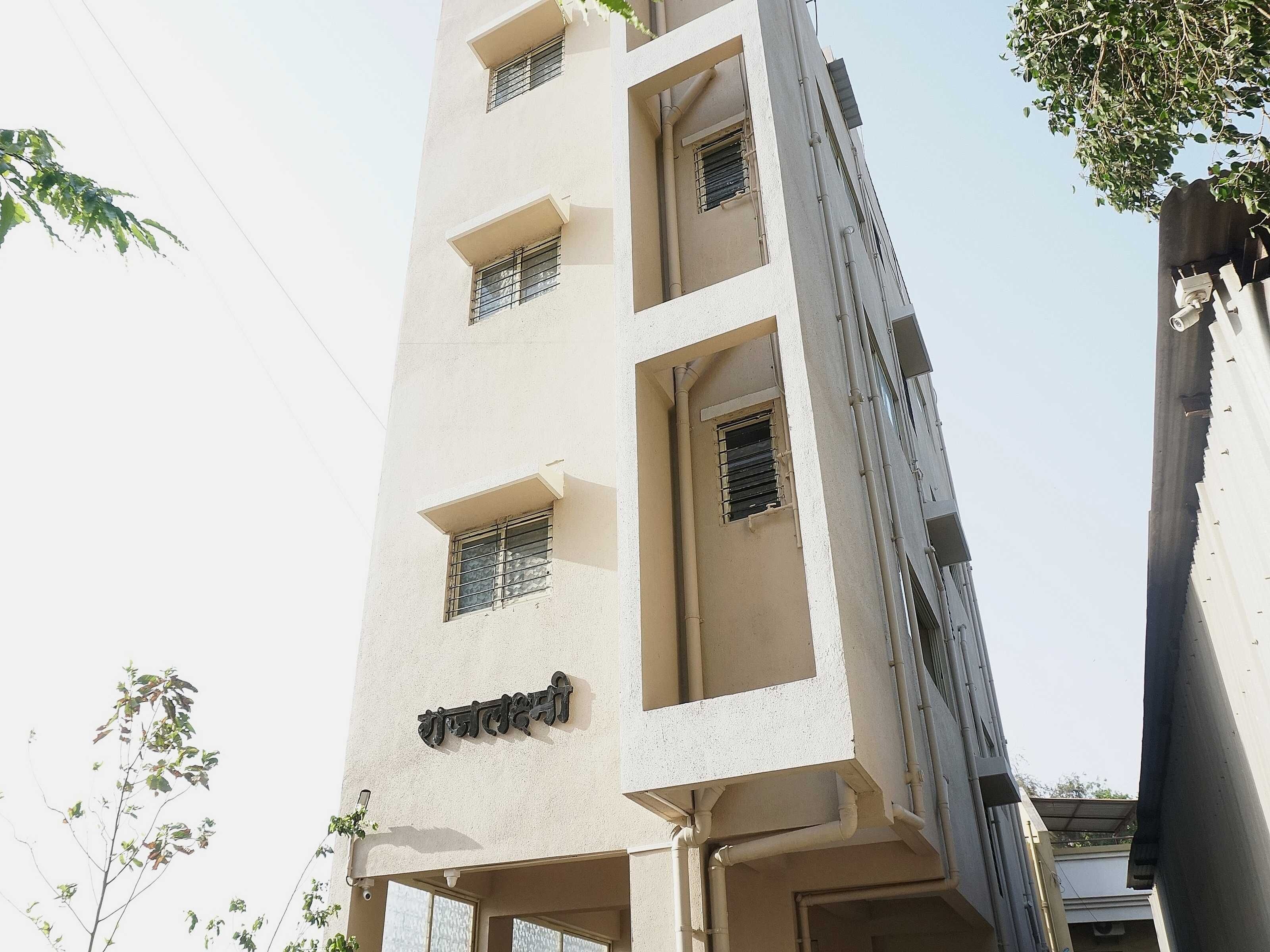 A multi-story building with several windows and a visible sign.