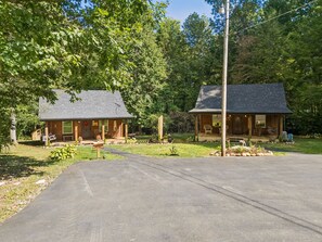 Eine zweistöckige Blockhütte mit Veranda und kleinem Vorgarten.