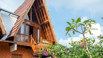A traditional wooden house with a sloped roof, a balcony, and a window.