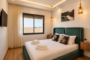 A modern bedroom with a large bed, a television, a window with curtains, and a painting on the wall. - AS269: Beautiful terrace on the 7th floor in downtown / free parking / fiber-optic Wi-Fi / tram (Casablanca)
