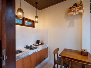 A kitchen with a wooden countertop, a gas stove, a sink, and hanging pendant lights. - Randama Villa with Private Pool and Kitchenette (Tegallalang)