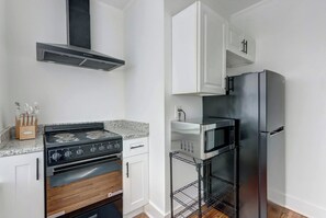 A kitchen with a stove, oven, microwave, and refrigerator. - Fresh Modern Apartment by Daffin (Savannah)