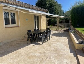 A patio area with a table and chairs, a pergola, and a garden. - Charming two-story villa with a pool for 8 people, near downtown (Vidauban)