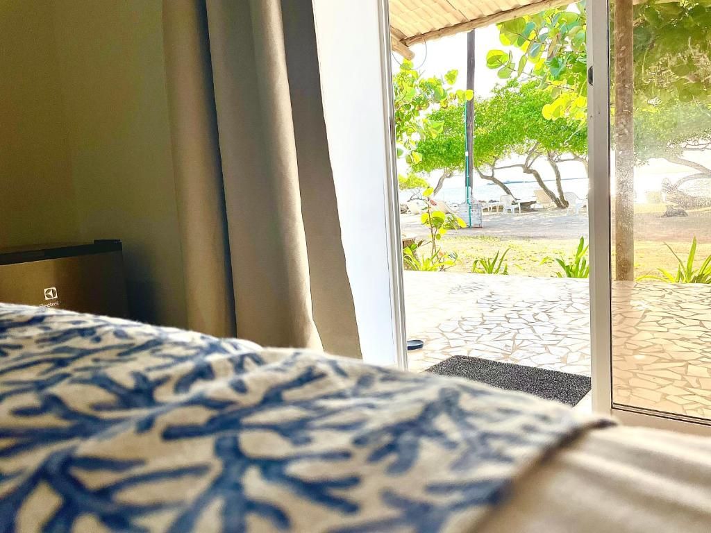 A hotel room with a bed, a window, and a view of the outdoor area.