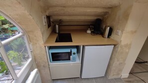 A compact kitchenette with a microwave, a small oven, and a sink. - Studio on patio in Chartrons (Bordeaux)
