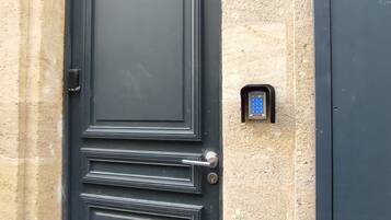 Una porta nera con una serratura a digitare e un piccolo oblò sopra.