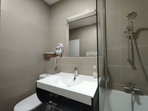 A modern bathroom with a white sink, a toilet, a shower, and a mirror. - Charmant studio aux Chartrons avec climatisation (Bordeaux)
