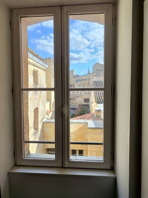 Ein Fenster mit Blick auf Gebäude und einen klaren Himmel.