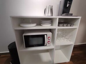 A white kitchen unit with a microwave, a kettle, and a coffee machine. - Apartment in mythical Chartrons floor 1 (Bordeaux)