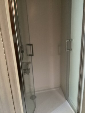 Eine Duschkabine aus Glas mit sichtbarer Duschbrause und Bedienfeld.
