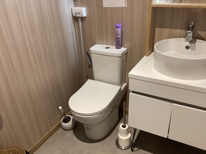 Ein modernes Badezimmer mit Toilette, Bidet und Waschbecken.