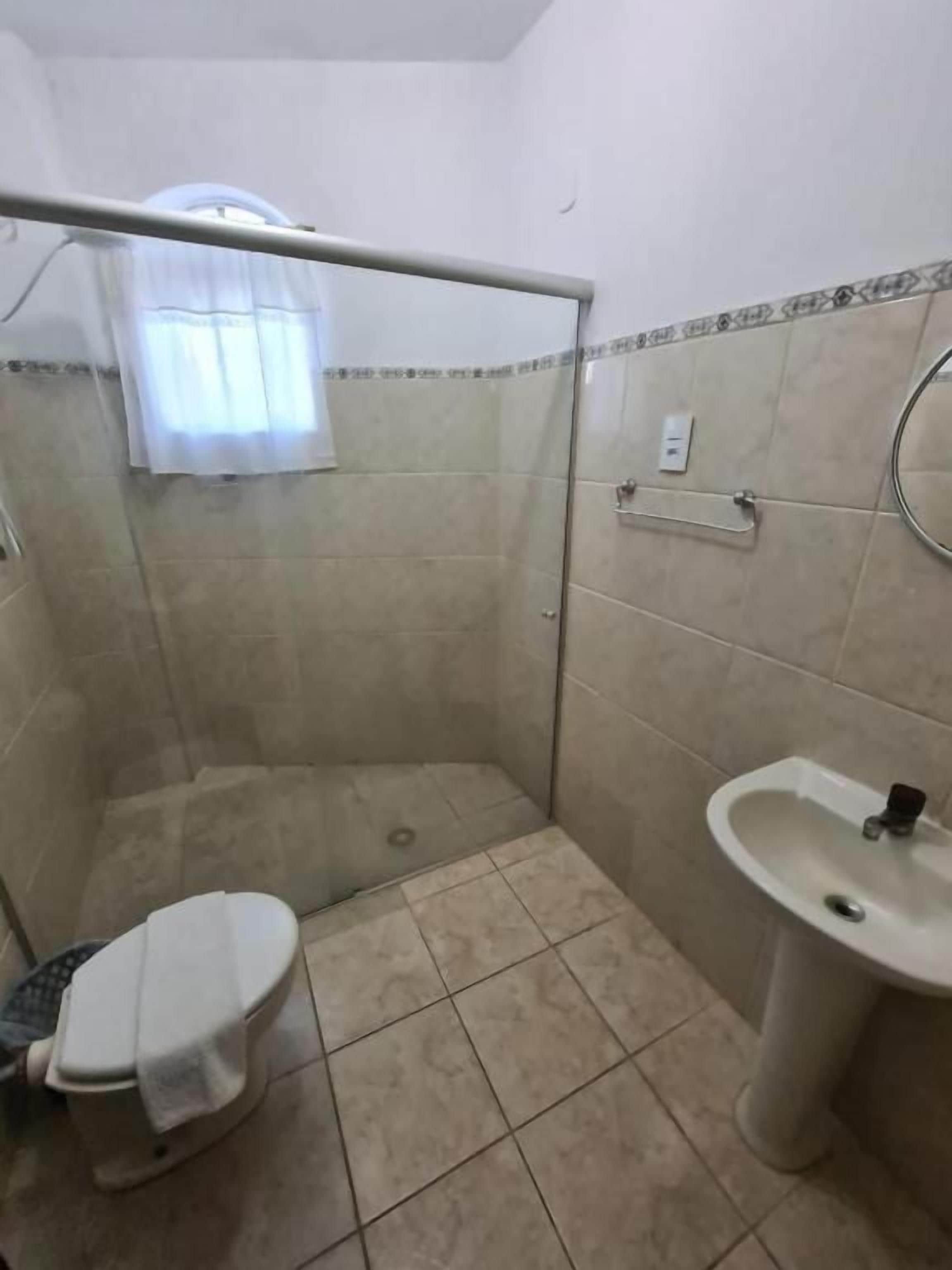 Ein Badezimmer mit Dusche, Toilette und Waschbecken.
