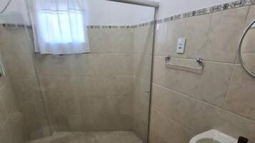 Ein Badezimmer mit Dusche, Toilette und Waschbecken.