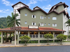 Un hotel con un cartel que dice 'Vitória Garden Hotel' y un área exterior cubierta con plantas.
