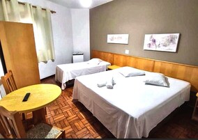 Una habitación de hotel con dos camas, una mesita, una silla y un escritorio.