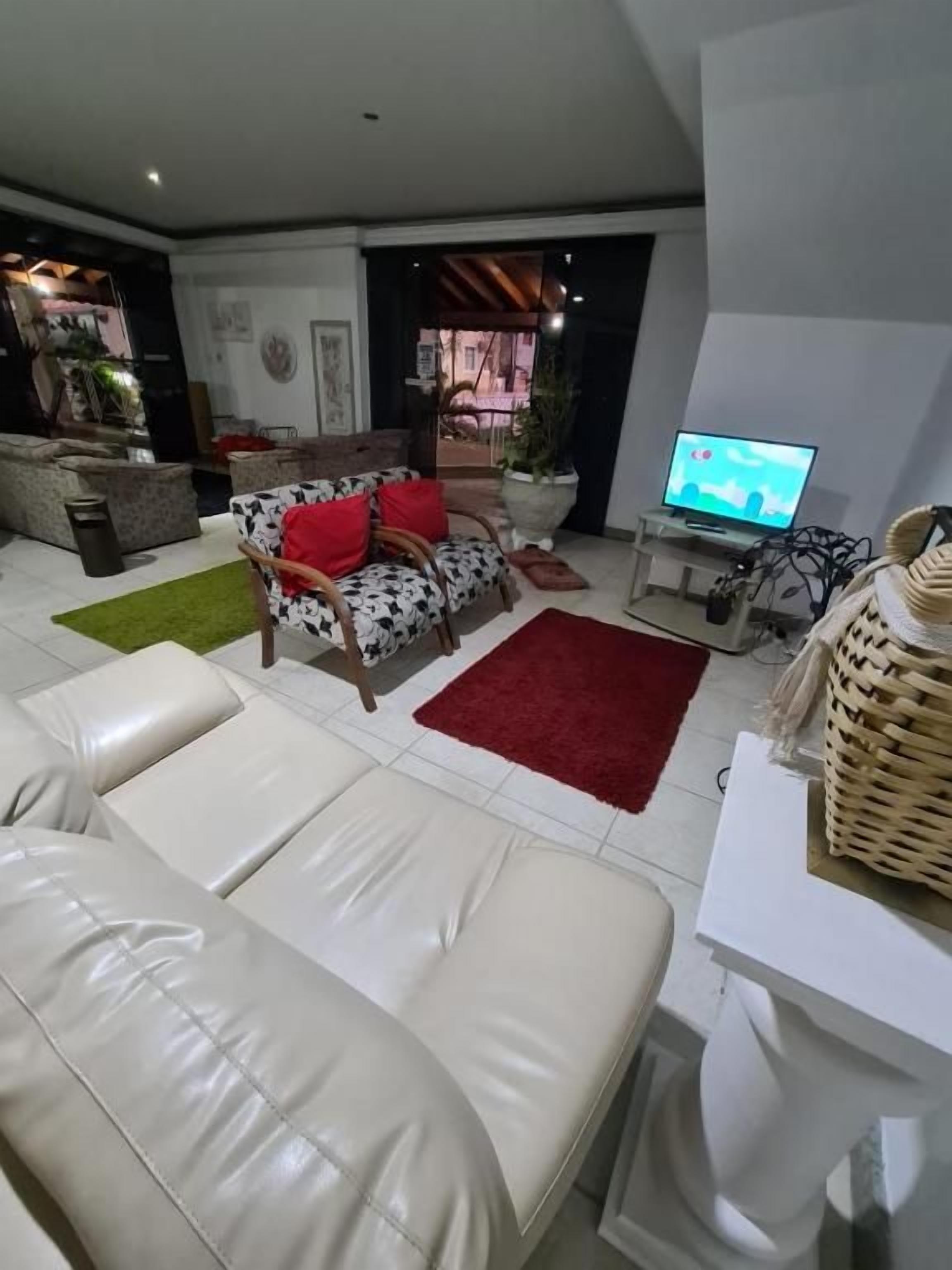 Un salon moderne comprenant un ensemble de canapés, un téléviseur et un coin repas.