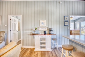 A kitchen with a bar area, wooden flooring, and striped wallpaper. - Toddle House- 5 Bds- Slps 10- dogs ok- canal view (North Myrtle Beach)