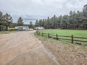 Een onverharde weg naar een omheind camping met daarop campers.