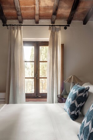 Une chambre à coucher avec un lit, des rideaux, une fenêtre et une lampe.