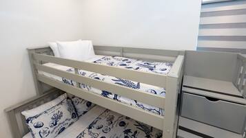 A bunk bed with a white mattress and blue patterned bedding.