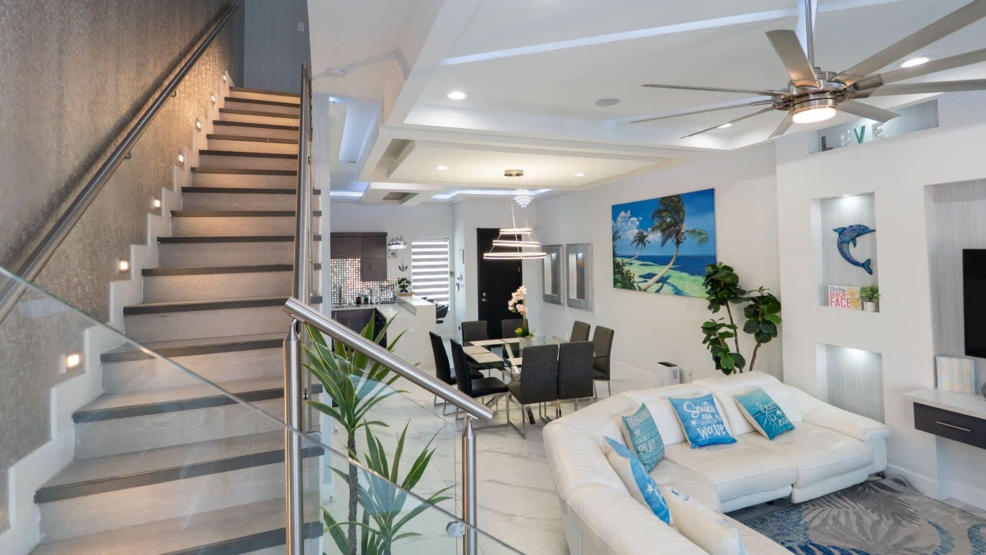 A modern interior with a staircase, dining area, and living space.