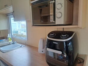 A kitchenette with a toaster oven, a kettle, and a built-in microwave. - Chapel Farm Holiday Park No 6 Bunnies View (Appleby-in-Westmorland)