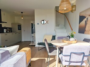 Ein modernes Interieur mit Essbereich, Küche und Treppe.