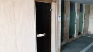 Une rangée de chambres d’hôtel avec des portes en bois et des planchers carrelés.