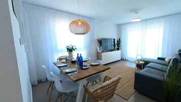 Ein modernes Wohnzimmer mit Essbereich, einer Couch, einem Fernseher und einem großen Fenster mit Vorhängen.