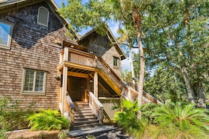 A wooden house with a balcony and stairs leading to the entrance. - Immaculate new villa, steps to Kiawah's famous beaches (Kiawah Island)