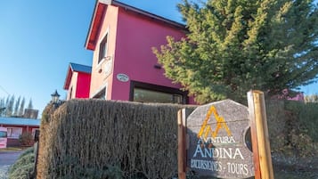 A building with a sign for 'Andina Excursiones Tours' and a clear sky.