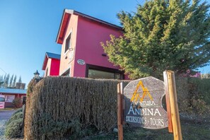 Un edificio con un cartel que dice 'Andina Excursiones Tours' y un cielo despejado.