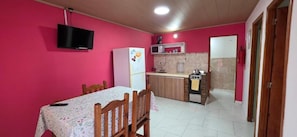 Cozinha compacta equipada com geladeira, micro-ondas e fogão.