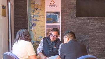 Un grupo de personas sentadas a una mesa con un mapa y un folleto frente a ellas.
