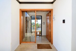 Un pasillo con una puerta de madera que da a una habitación con vistas a un paisaje natural.