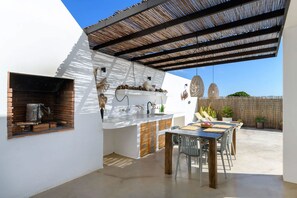An outdoor patio with a grill, bar area, and seating. - Gorgeous 2-bedroom house in tranquil Mácher perfect for relaxing stays (Tías)