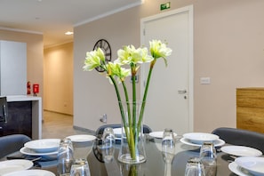 A conference room with a round table, clear glass vases with flowers, and a clock on the wall. - Luxury 3-bed With Private Terrace in St Julian s (St. Julian's)