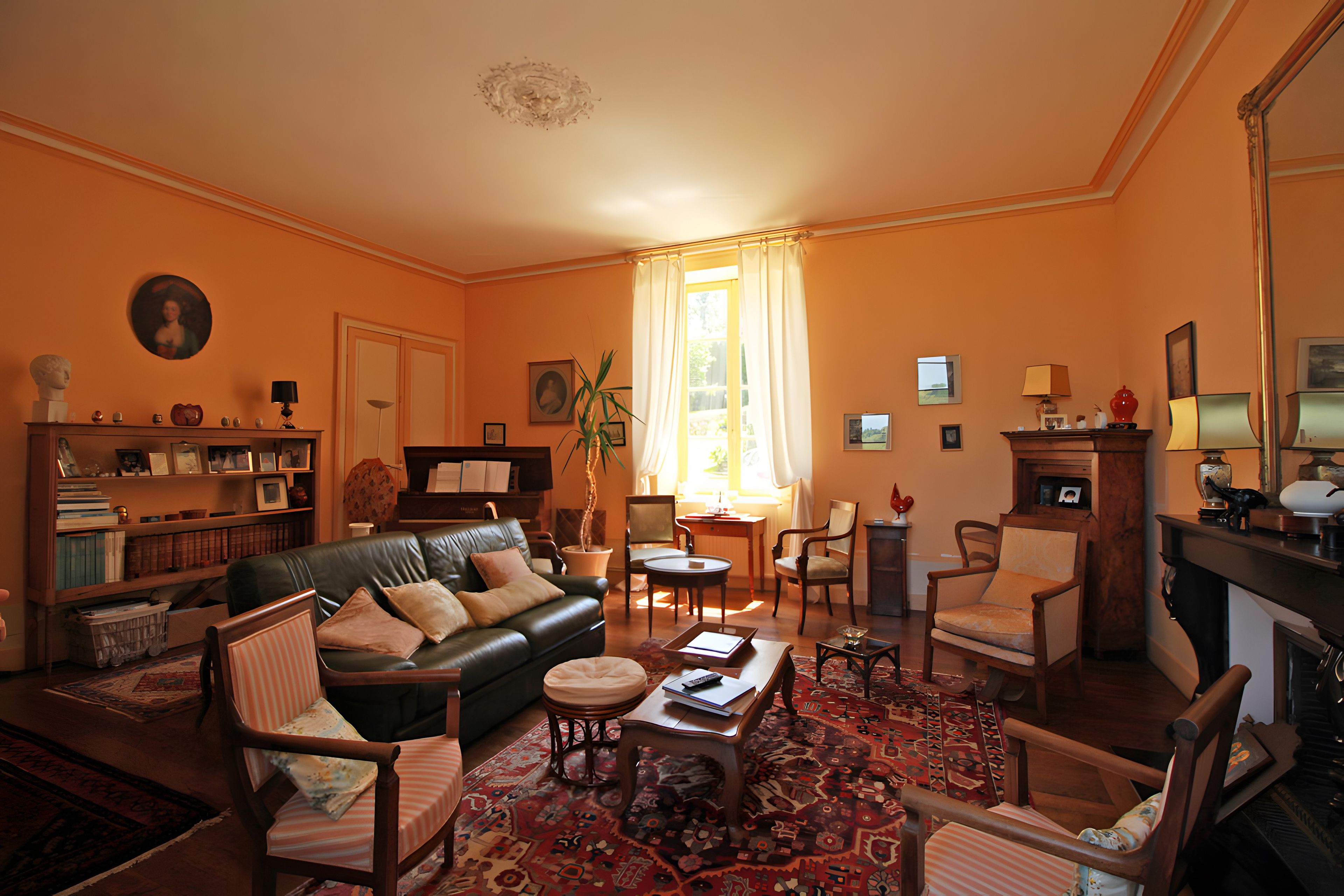 Un salon traditionnel avec un canapé en cuir, des fauteuils, une table basse et une cheminée.